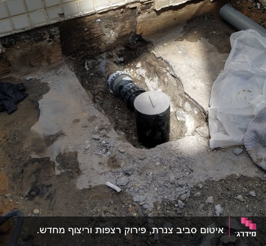 צינור שחור עם מכסה לבן בתוך חפירה ברצפה